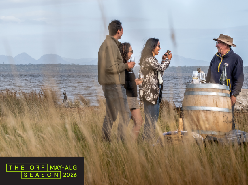 People gathered around a wine barrel drinking wine