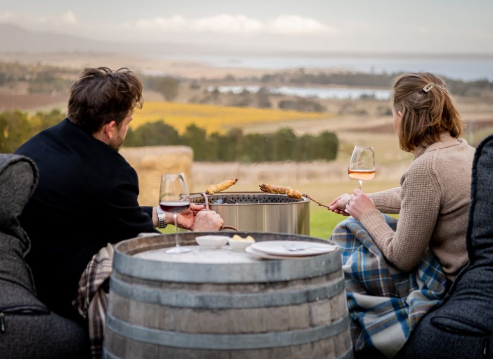 A man and woman enjoying a glass of wine by the fire