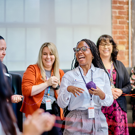 Devoted Health members gather at the office, smiling and laughing.