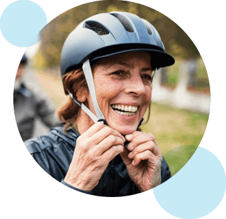 Active Devoted Health member wearing a helmet while riding a bike in the park.