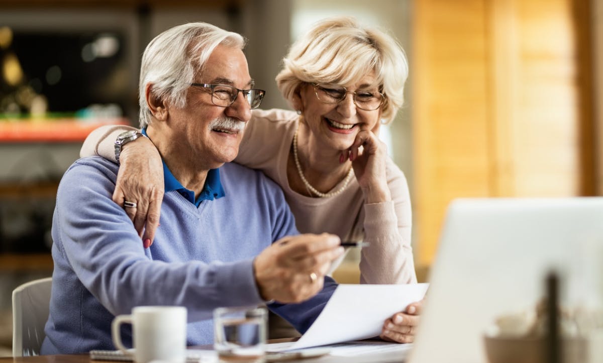 Smiling couple reviewing paperwork.