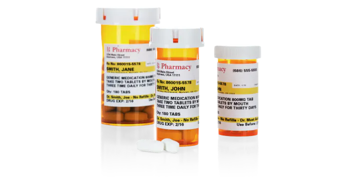 Three prescription pill bottles of different sizes with two white pills in front.