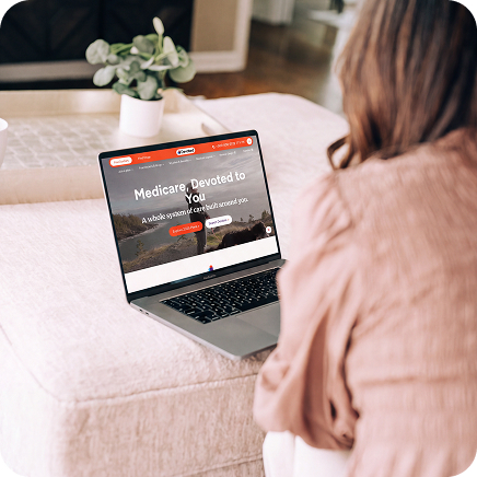 Insurance broker viewing Devoted Health plan options on a laptop.