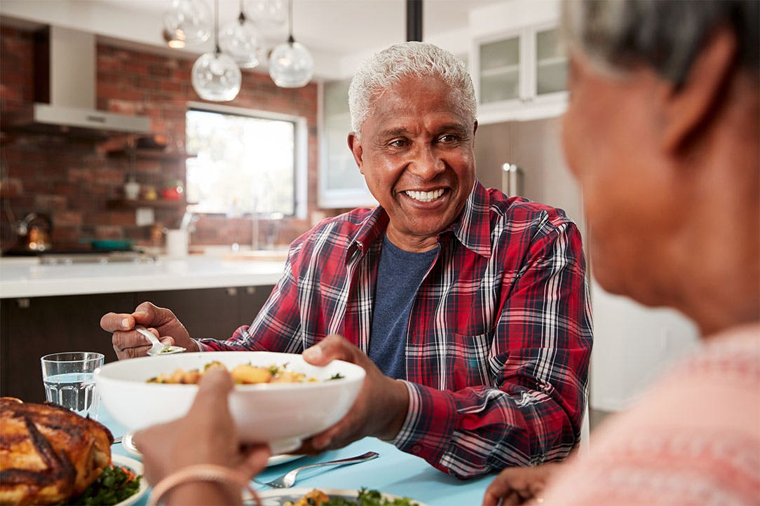 Senior couple enjoying a meal at a the kitchen table.