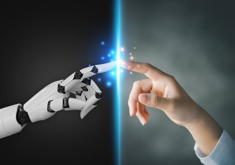 A robot hand and human hand meeting in the middle.