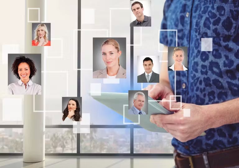 A man holding a tablet with different images of people.  