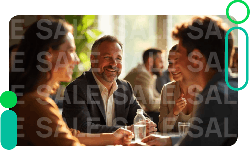 Group of people having a discussion around a table, smiling.