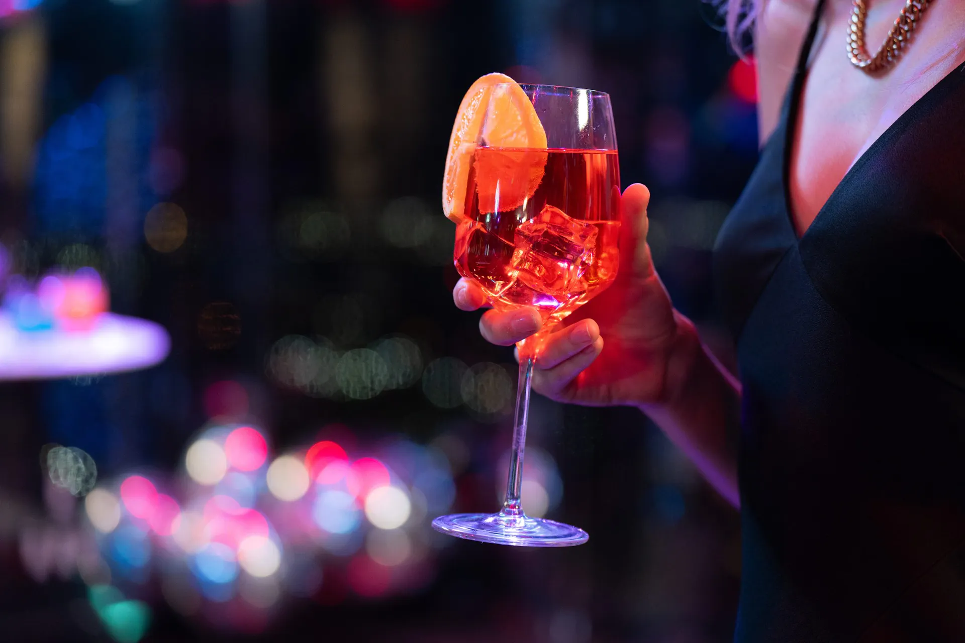 A guest holding a cocktail at an evening reception at SUMMIT Events