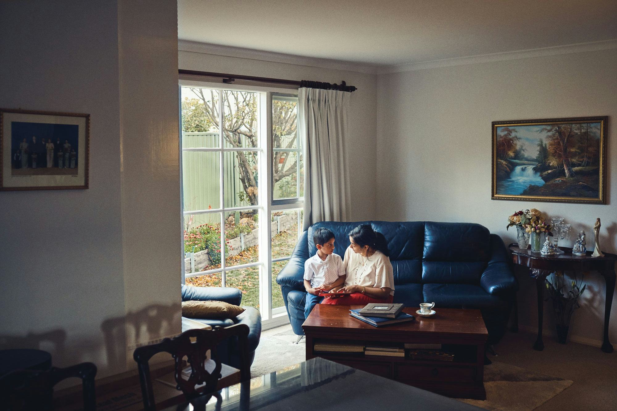 A mother and son on a couch in their home