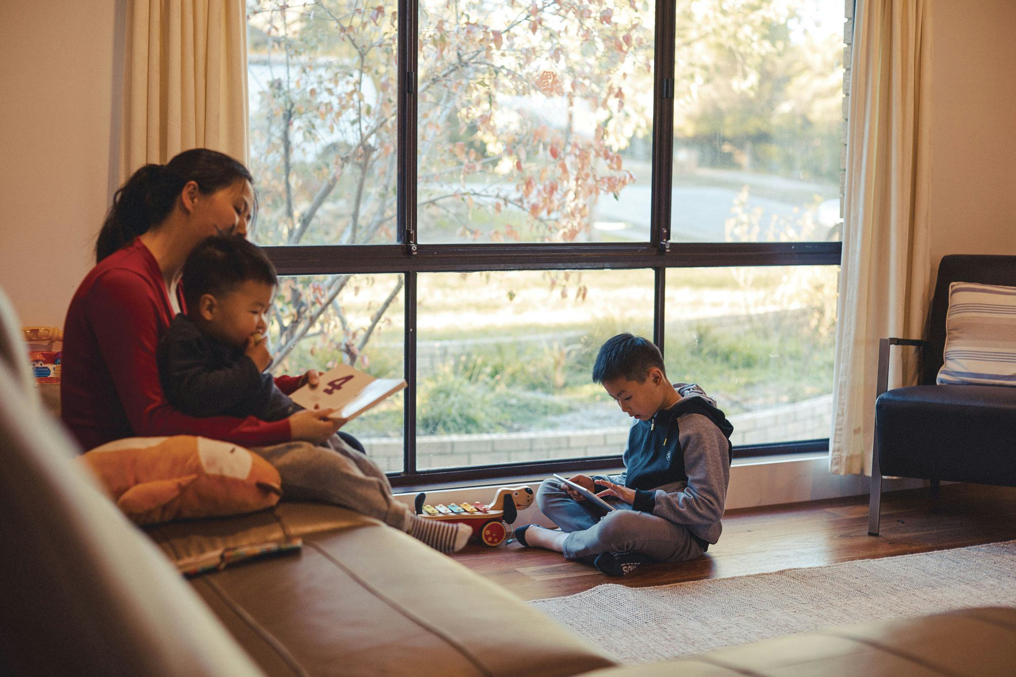 A family sitting in a living room accessing the Library's digital archives on a tablet