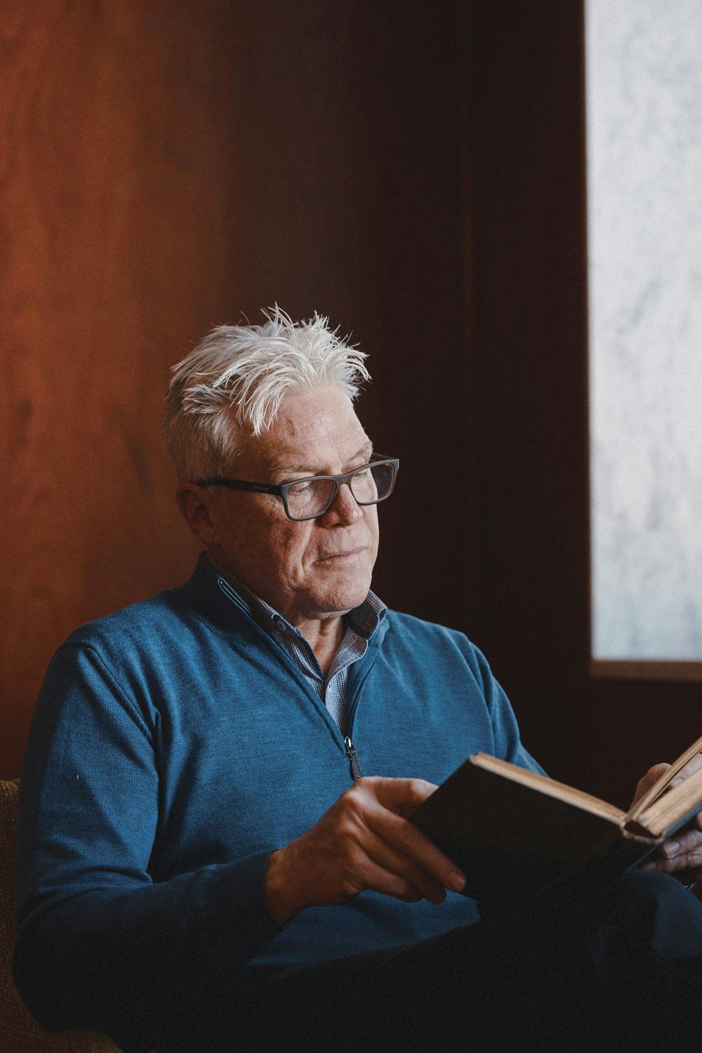 A person reading a book from the Library's archives