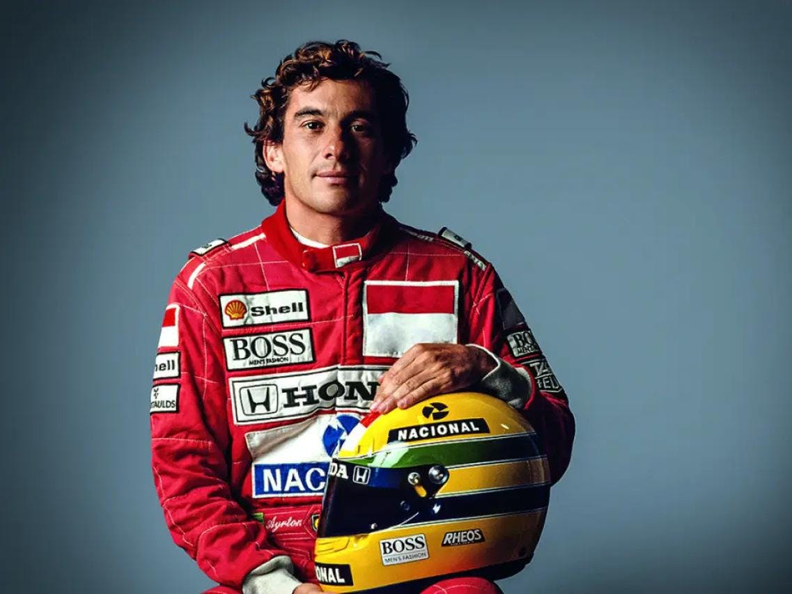 Foto de Ayrton Senna com capacete amarelo e verde nas mãos