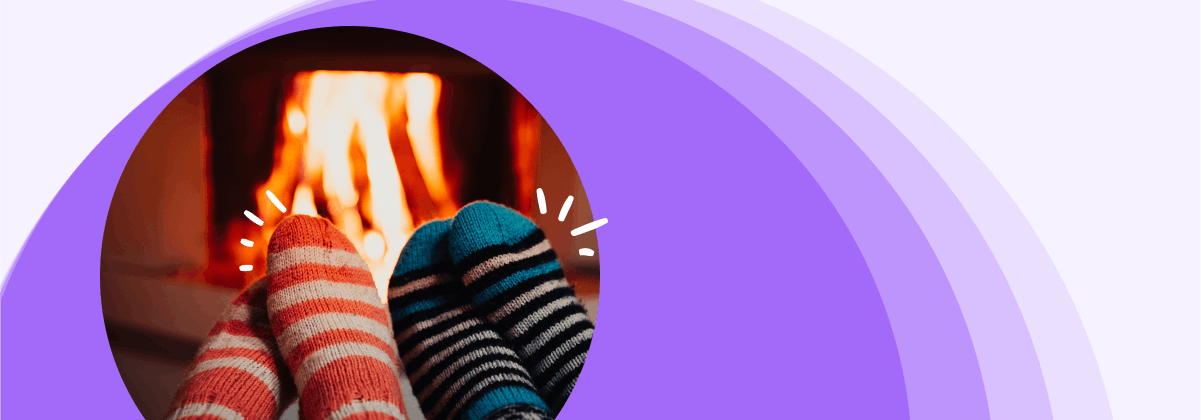 Two people wearing socks and sitting by the fire 