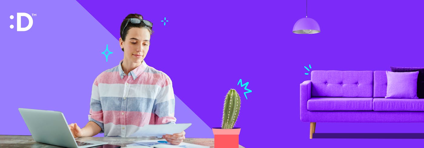 a woman working on her laptop with a purple couch in the background