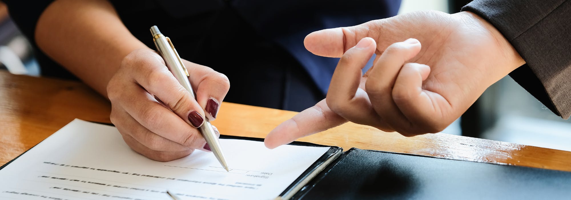 A first home buyer signing a document for a first home owners grant in NSW