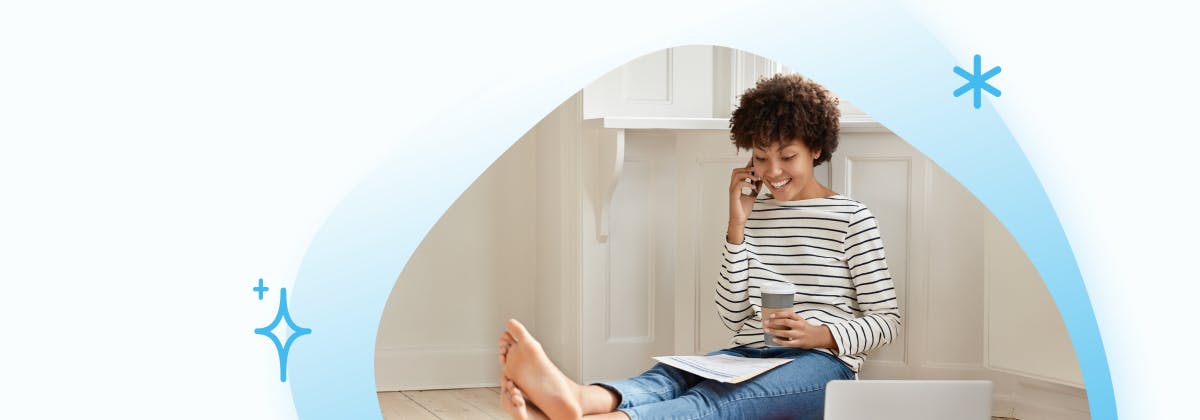 A woman relaxing on the floor with a coffee reading 