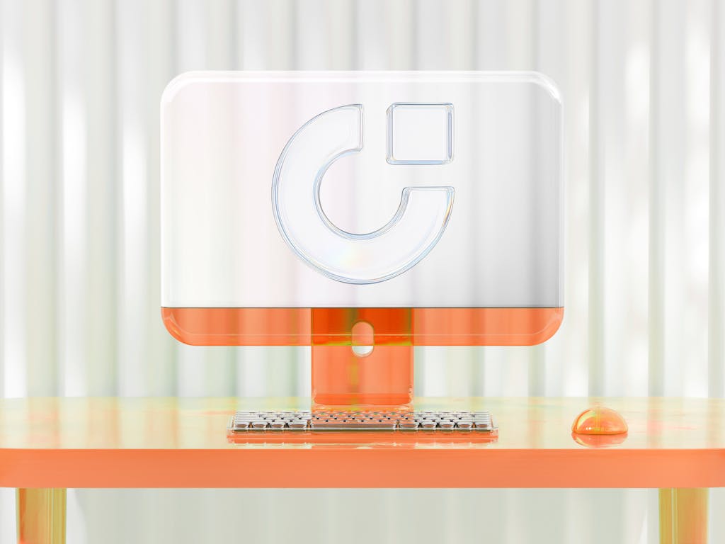 Transparenter Computer auf orangefarbenem Schreibtisch – modernes Webdesign und digitale Markenpräsenz