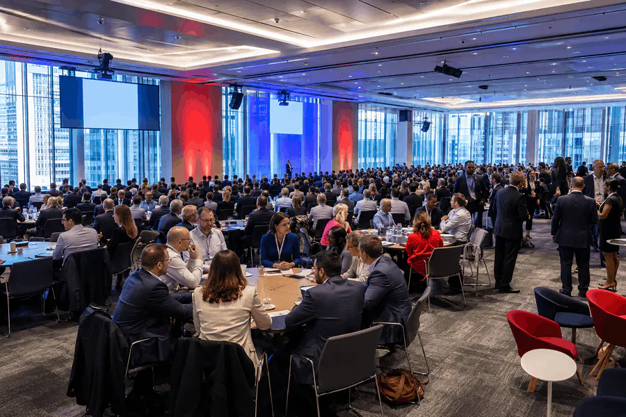 Attendees gathered in a round-table setup during a plenary session of a Transport for London professional event