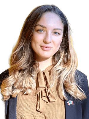 Portrait de Juliette Vérin portant un blazer noir et un chemisier beige.