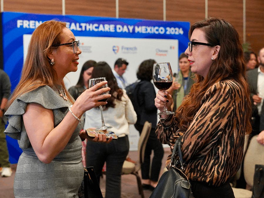 Deux participantes échangeant lors d’un moment de networking avec un verre de vin pendant le French Healthcare Day Mexico 2024 organisé par Business France.