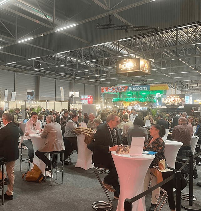 Professionnels échangeant autour de tables hautes dans l’espace networking du salon CCI Alsace Eurométropole.