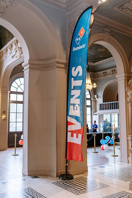 Domino’s Pizza banner displayed in an elegant hall during a company event.