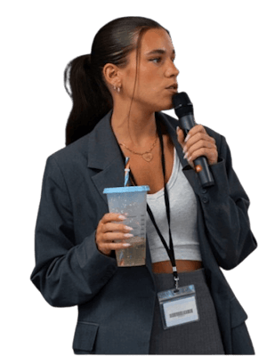 Julie Veros speaking on stage with a microphone during an event.