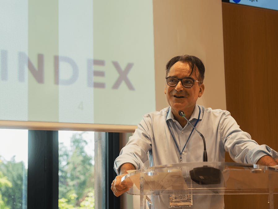 Orador a falar num púlpito durante uma conferência organizada pela CINDEX.