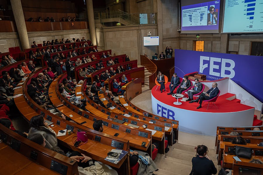Vue d’ensemble d’une conférence au Forum Économique des Banlieues au Palais d’Iéna à Paris, où plusieurs intervenants échangent sur scène devant un amphithéâtre rempli de participants, décideurs et professionnels.