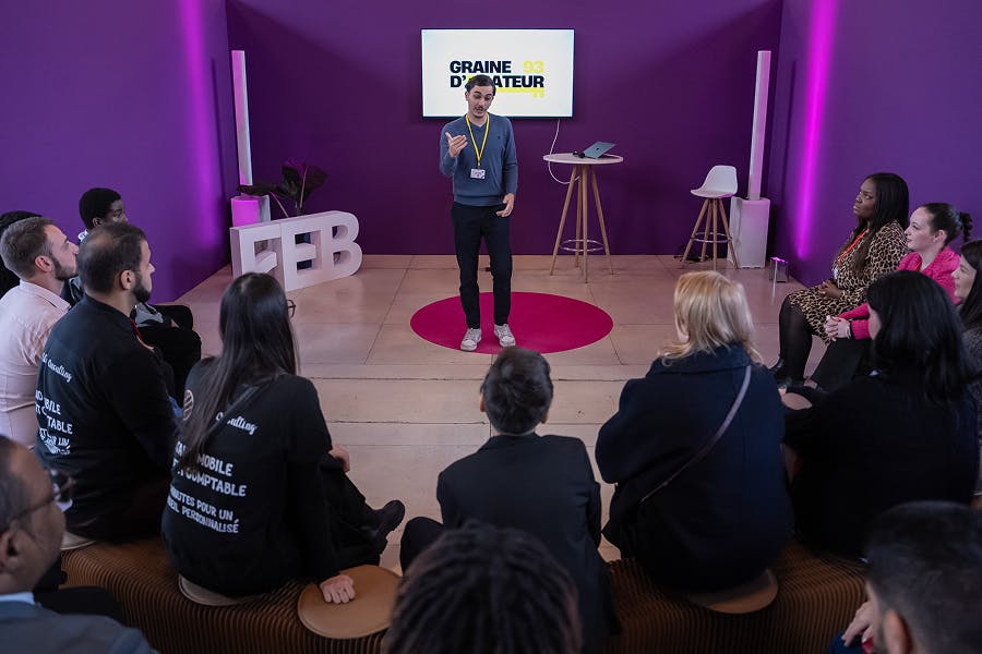 Un intervenant anime une session “Graine d’Entrepreneur” devant un petit groupe de participants lors du Forum Économique des Banlieues, favorisant échanges et partage d’expérience.