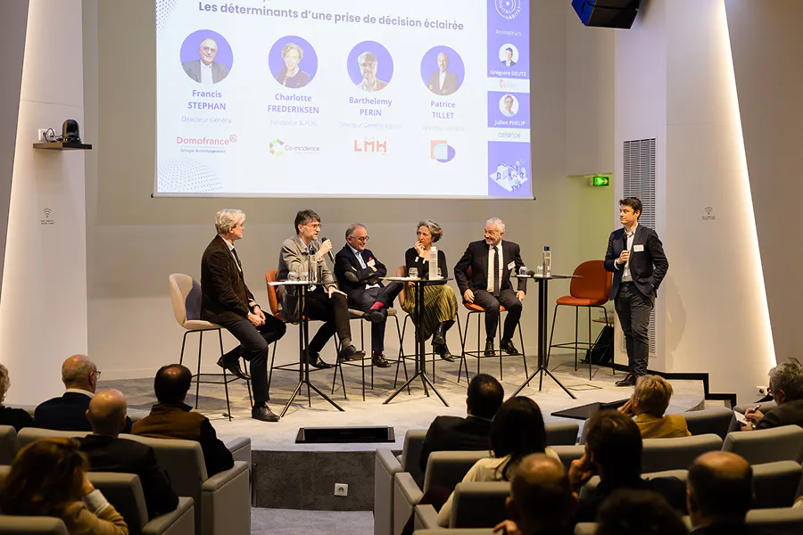 Mesa-redonda com especialistas durante o Digital Habitat, um evento híbrido B2B, reunindo participantes presencialmente em auditório e audiência online em torno da tomada de decisão estratégica.