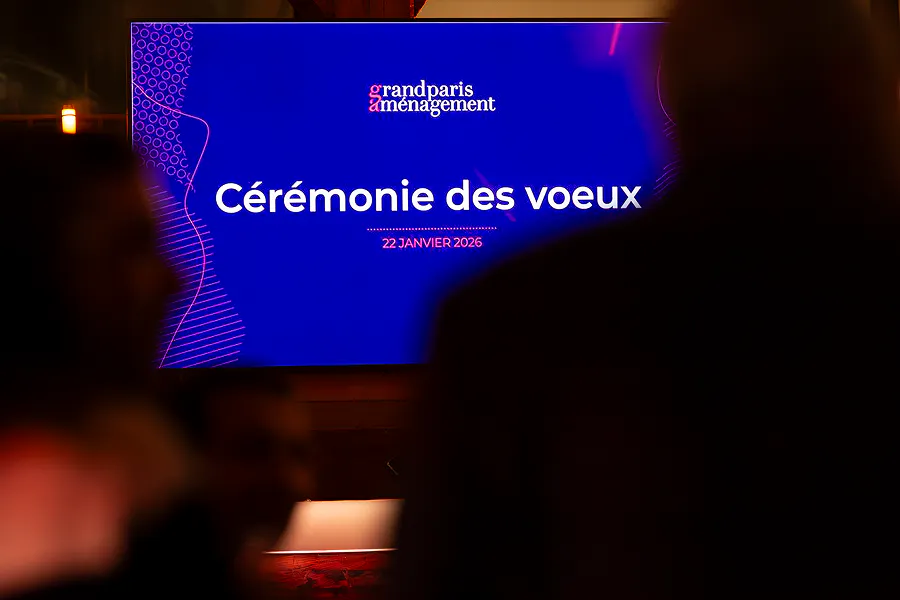 Écran affichant le titre "Cérémonie des vœux — 22 janvier 2026" avec le logo de Grand Paris Aménagement, devant une salle en attente. ©Gael_Kazaz