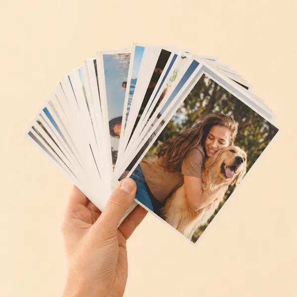 Mão segurando leque de 100 fotos 10×15 reveladas