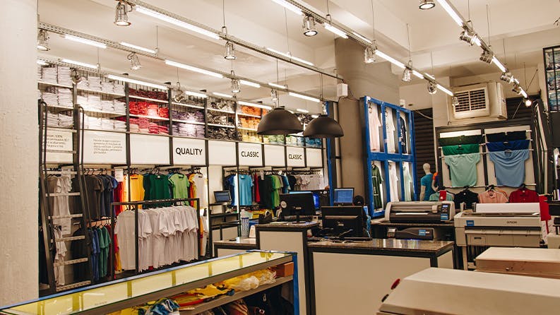 Interior da loja da Dimona em Copacabana com várias araras com blusas