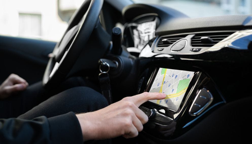 un conducteur utilise son gps dans sa voiture