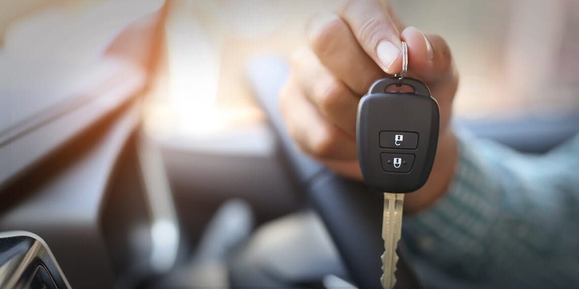 une main qui tend des clés de voiture