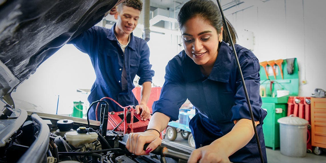 homme et femme apprenti mecanicien moteur voiture