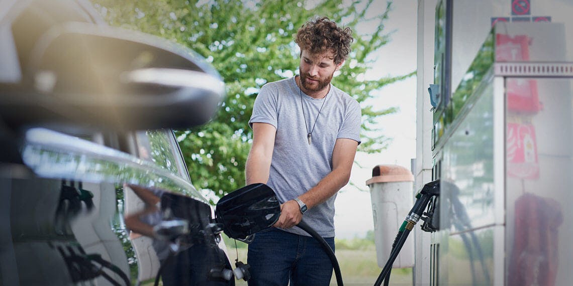 homme voiture plein essence station service