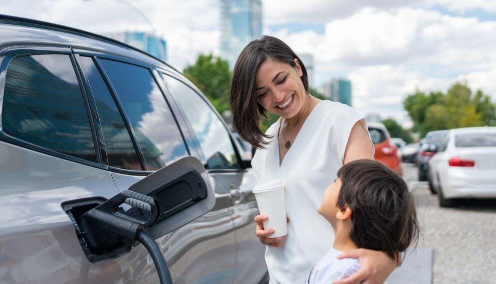 Deux regards souriants d'une mère et de son enfant devant une voiture électrique