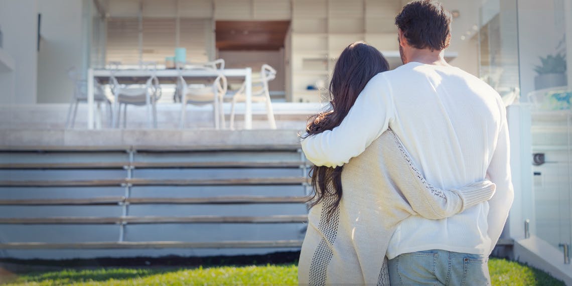 jeune couple de dos devant terrasse maison neuve
