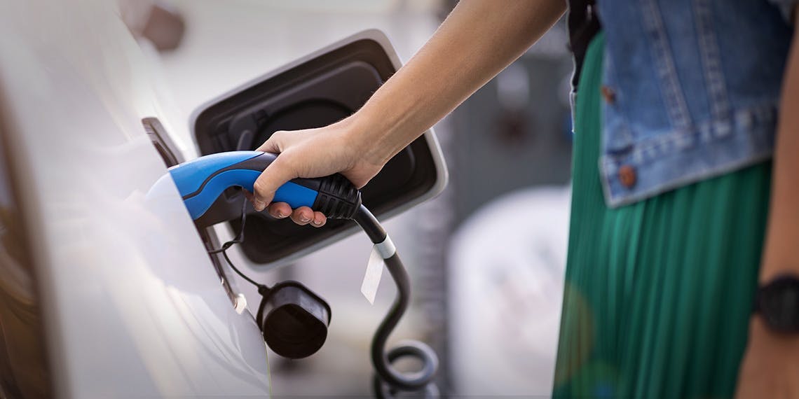 femme en train de charger voiture électrique