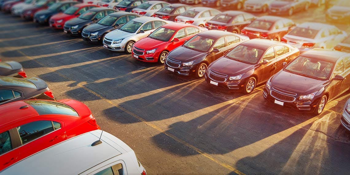nombreuses voitures neuves sur un parking 
