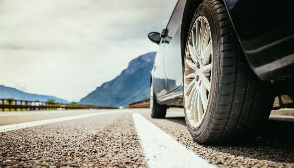 une voiture sur une route avec ses pneus en gros plan