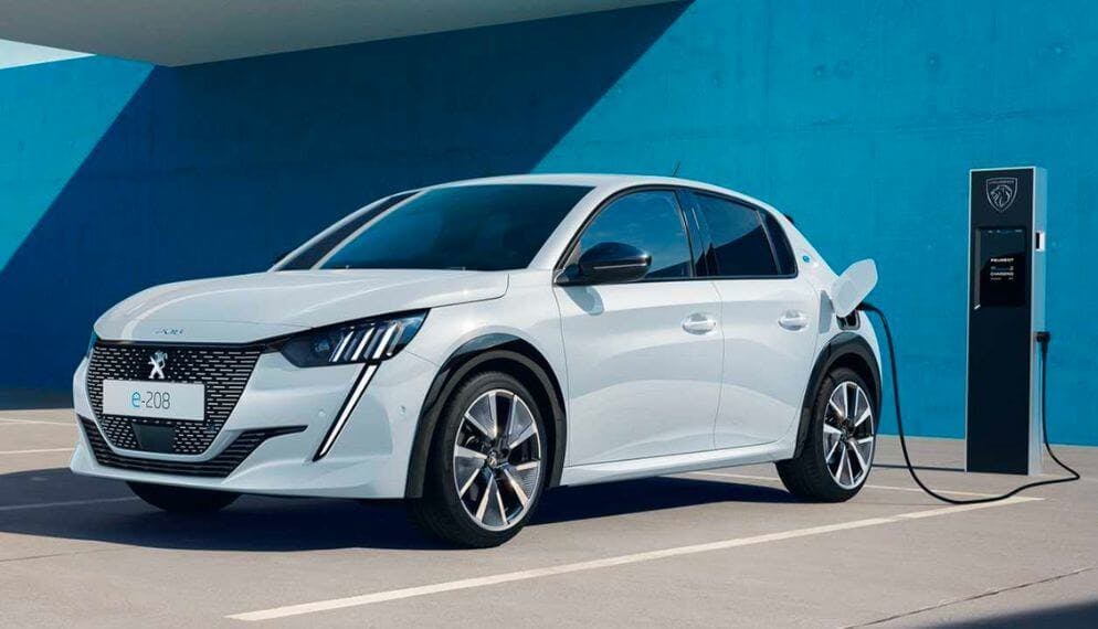 Une Peugeo e-208 en train de recharger sur une borne électrique