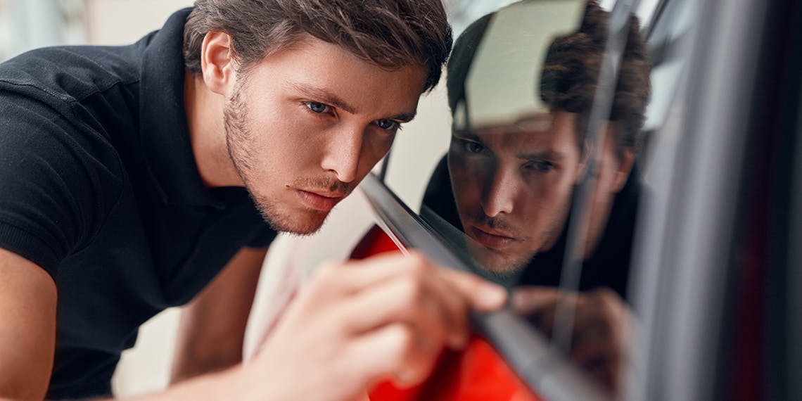 homme jeune observation caoutchouc vitre voiture
