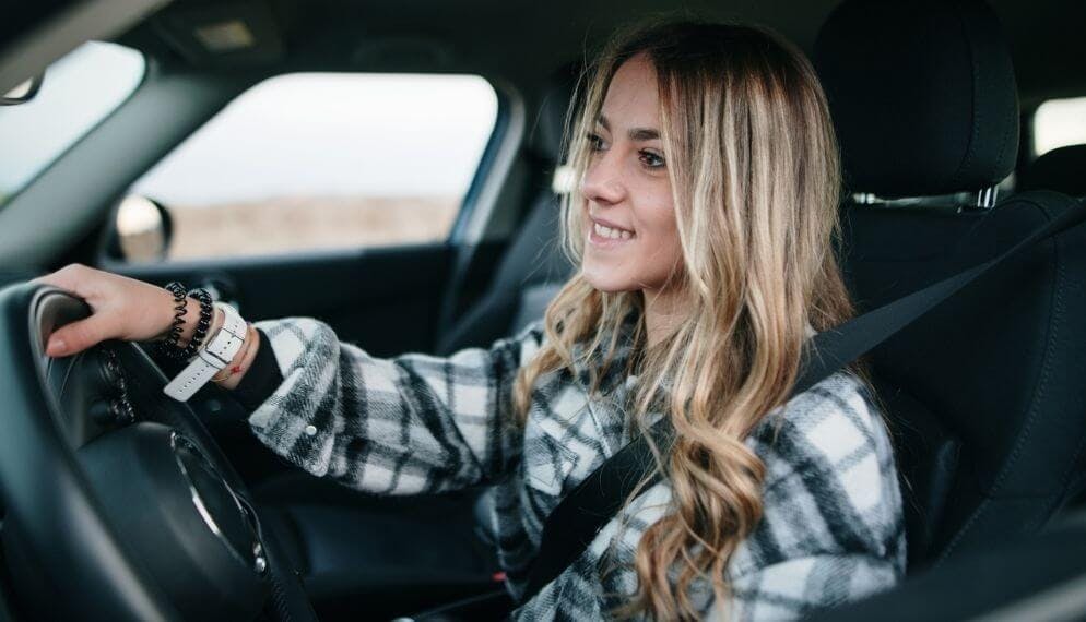 une jeune femme au volant de sa voiture