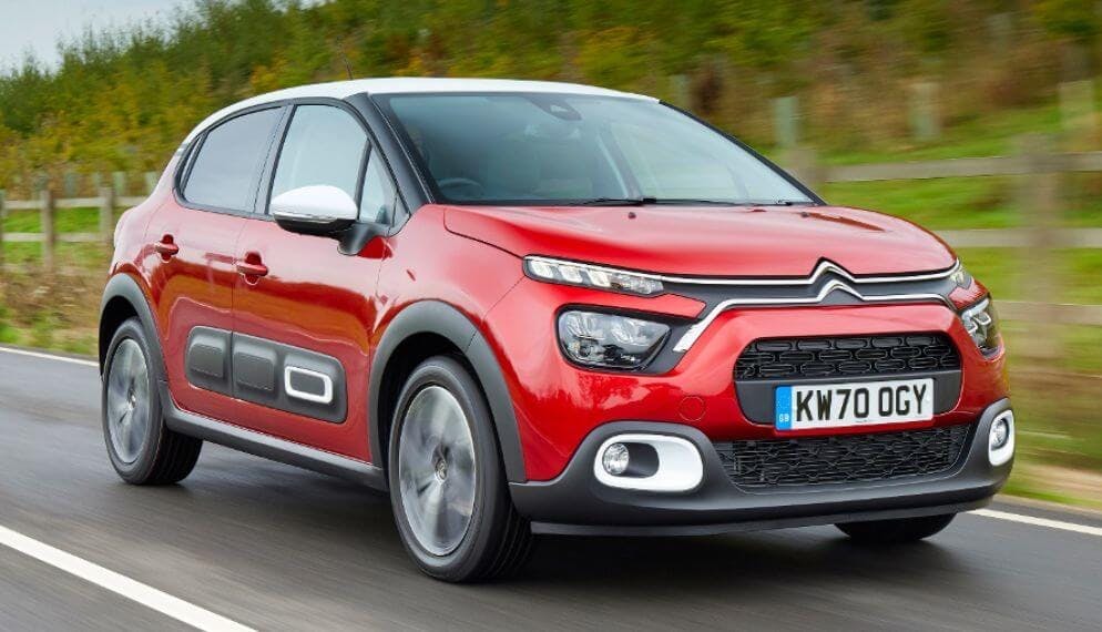 une voiture Citroën C3 rouge sur une route de campagne