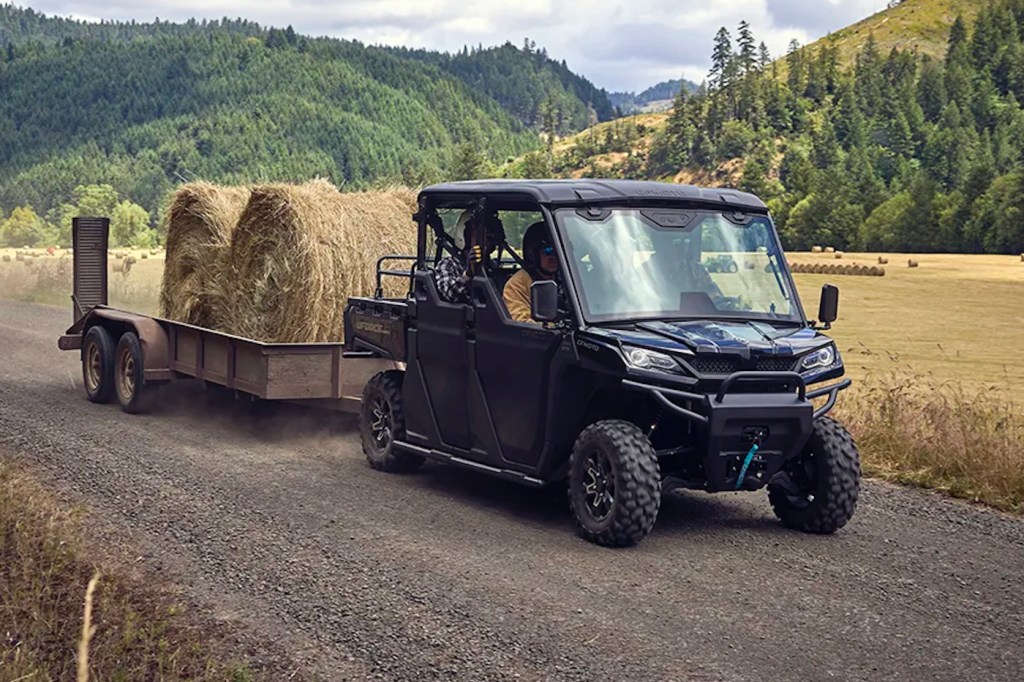 2025 CFMoto UForce 1000 XL pulling a trailer full of hay.