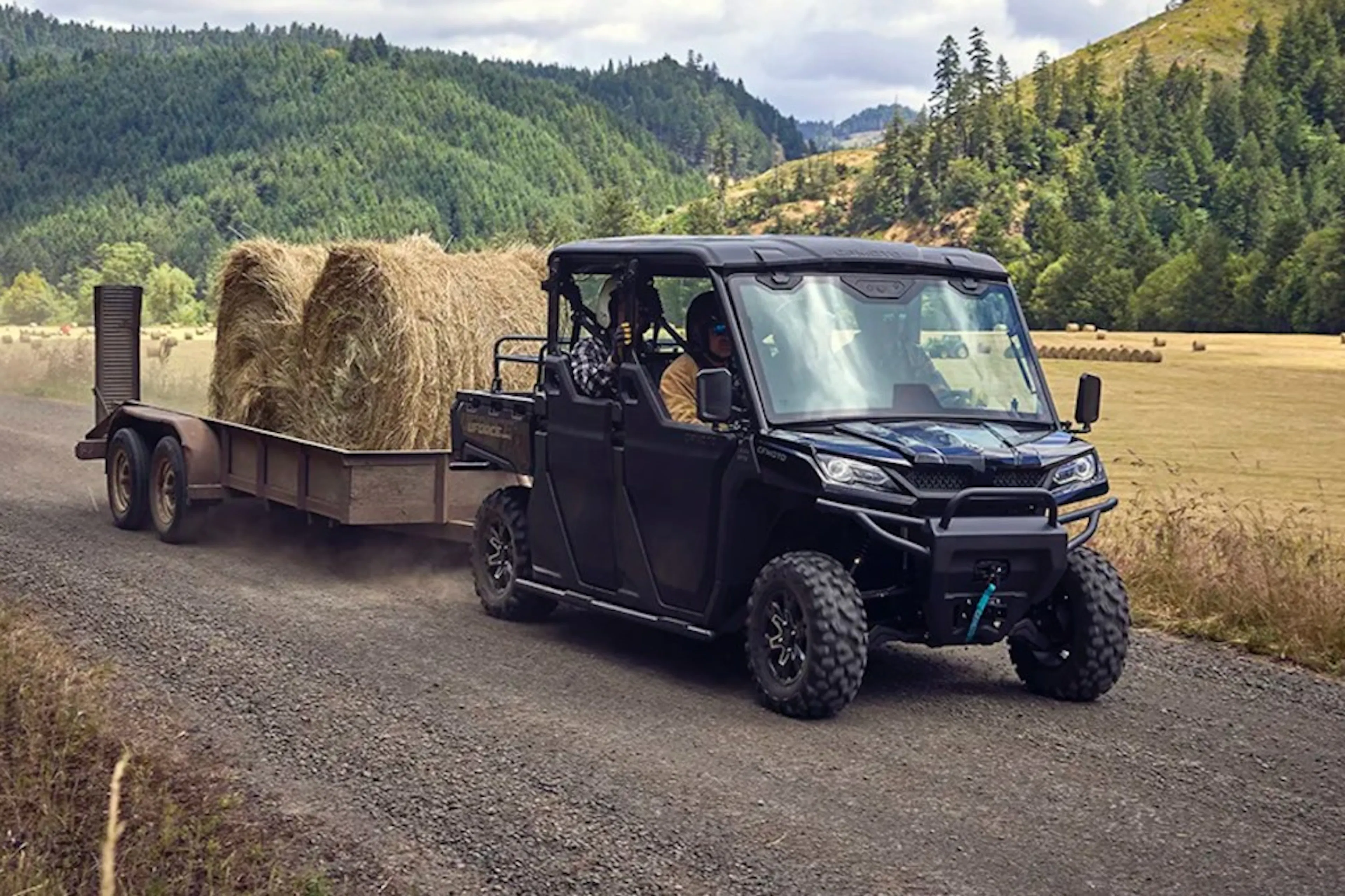 2025 CFMoto UForce 1000 XL pulling a trailer full of hay.