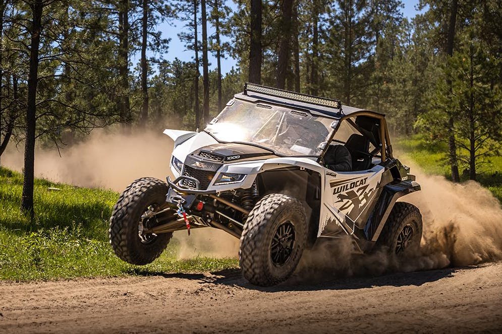 2025 arctic cat wildcat xx hitting that three wheel motion in the dirt.